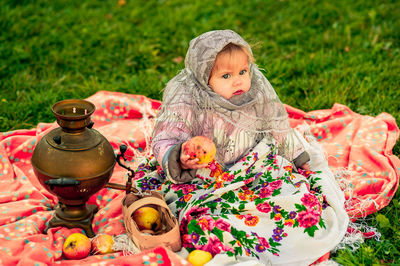 Portrait of young woman sitting on field