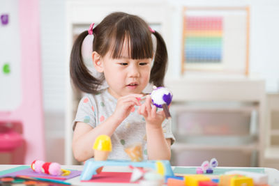 Young girl decorating hand made craft for homeschooling