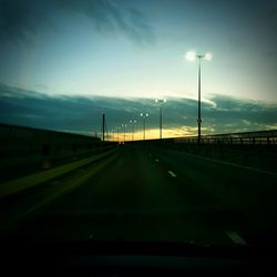 Road by street against sky at dusk
