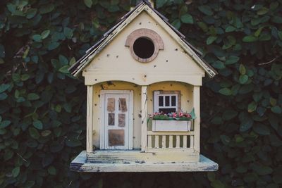 Wooden birdhouse against leaves