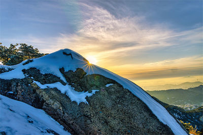 Scenic view of snowcapped mountains against sky during sunset