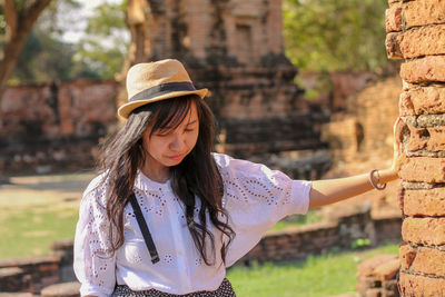 Portrait of woman wearing hat standing outdoors