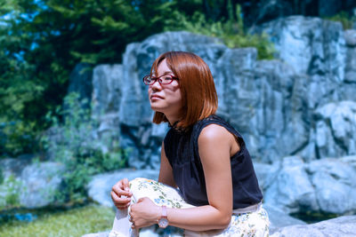 Portrait of young woman sitting on field