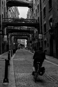 Rear view of man walking on street in city