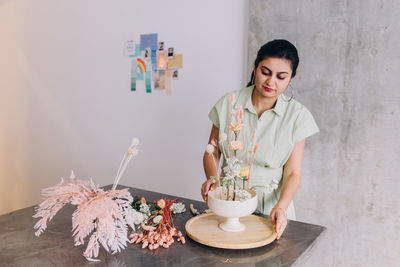 Portrait of young woman holding a ikebana arrangement 