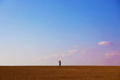 Man standing on field against sky