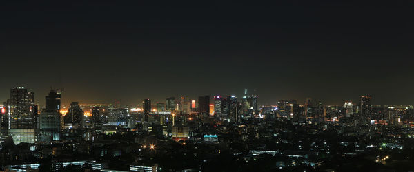 Illuminated buildings in city against sky at night