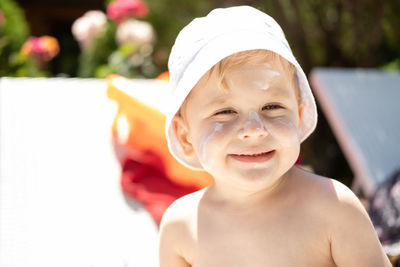 Cute boy wearing hat sitting on beach