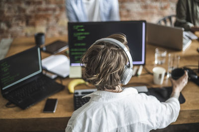 Female hacker working over computer at creative office