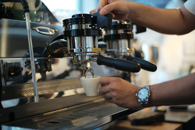 Cropped hand of man working in cafe