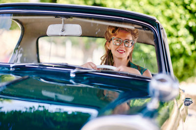 Smiling woman driving vintage car
