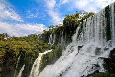 Scenic view of waterfall against sky