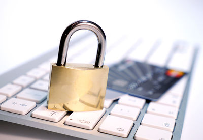 Close-up of padlock and credit card on keyboard