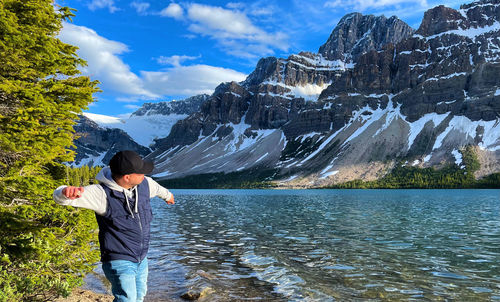Man standing by lake against mountains