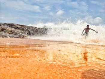 Man surfing in sea against sky