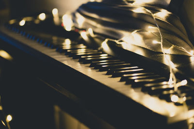 Close-up of illuminated string light on piano