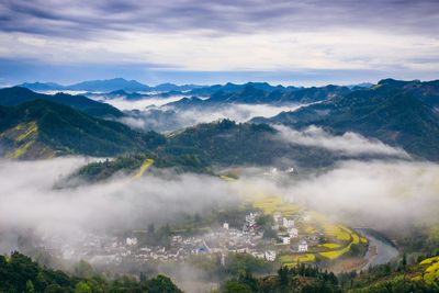 Scenic view of clouds touching mountains