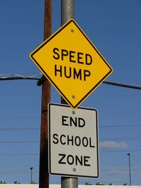 Close-up of road sign against clear blue sky