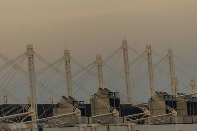 Cranes at construction site against sky during sunset