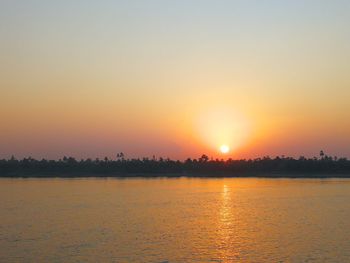 Scenic view of lake against orange sky