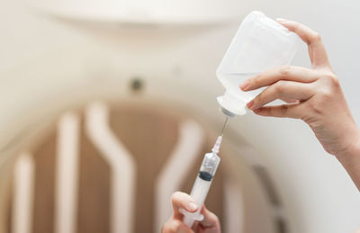 Cropped hands of doctor holding syringe at hospital