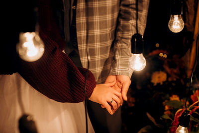 Midsection of man holding illuminated lighting equipment