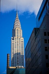 Low angle view of modern buildings against blue sky
