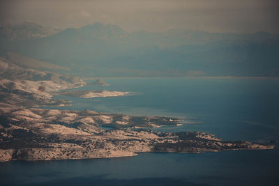 Aerial view of sea and mountains against sky