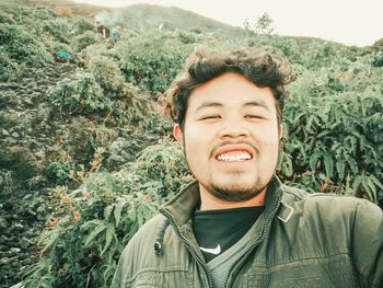 Portrait of smiling young man against plants