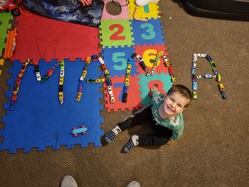 High angle view of boy playing with toys on floor