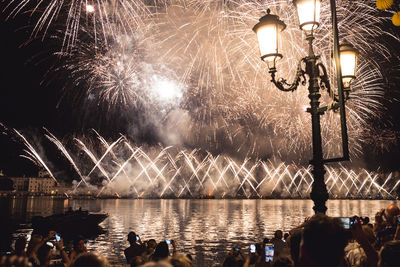 People watching firework display at night