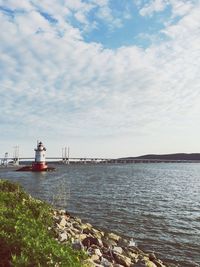 Lighthouse by sea against sky