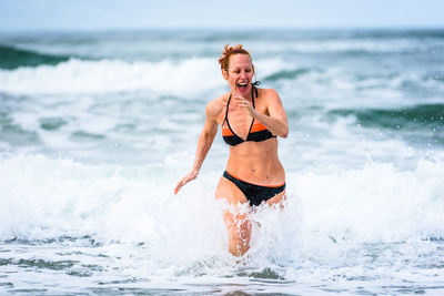 Happy woman wading in sea
