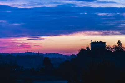 Silhouette buildings against sky at sunset