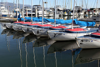 Boats moored with reflection at harbor
