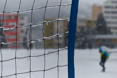 Close-up of man seen through fence