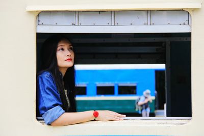 Young woman looking through train window