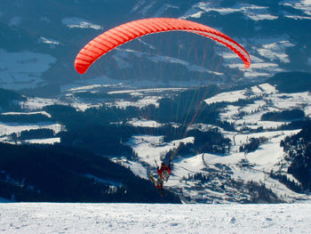 Person paragliding over mountain