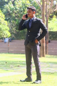 Man in formal suit , talking on phone