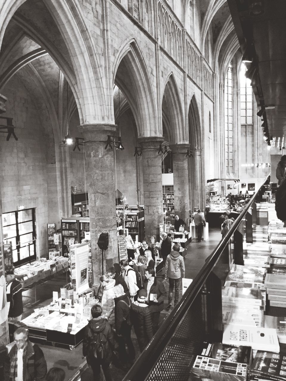 indoors, arch, architecture, built structure, ceiling, in a row, interior, men, incidental people, person, chair, day, retail, hanging, large group of objects, transportation, architectural column, large group of people, place of worship