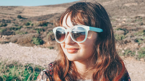 Portrait of woman wearing sunglasses on field