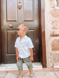 Full length of boy standing against door