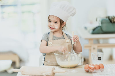 Portrait of girl holding ice cream on table