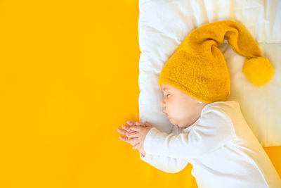 Cute baby girl against yellow background