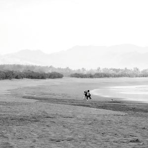 Men on beach against sky