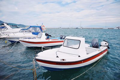 Sailboats moored on sea against sky