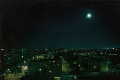 Illuminated cityscape against sky at night