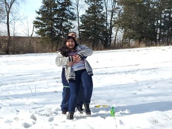 Full length of young woman on snowy field