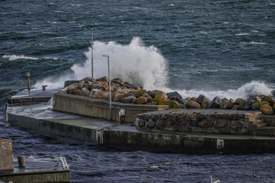 Waves splashing on rocks by sea