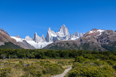 Scenic view of mountains against clear blue sky